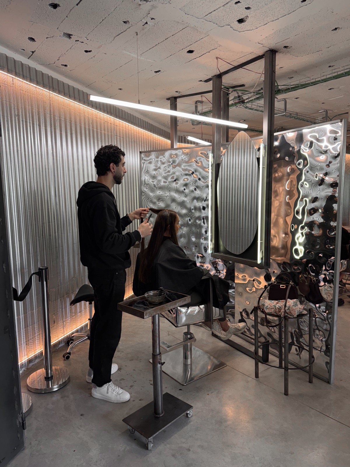 Estaciones de peinado en cromo junto a la pared de acero corrugado, Garage Hair Club Marbella
