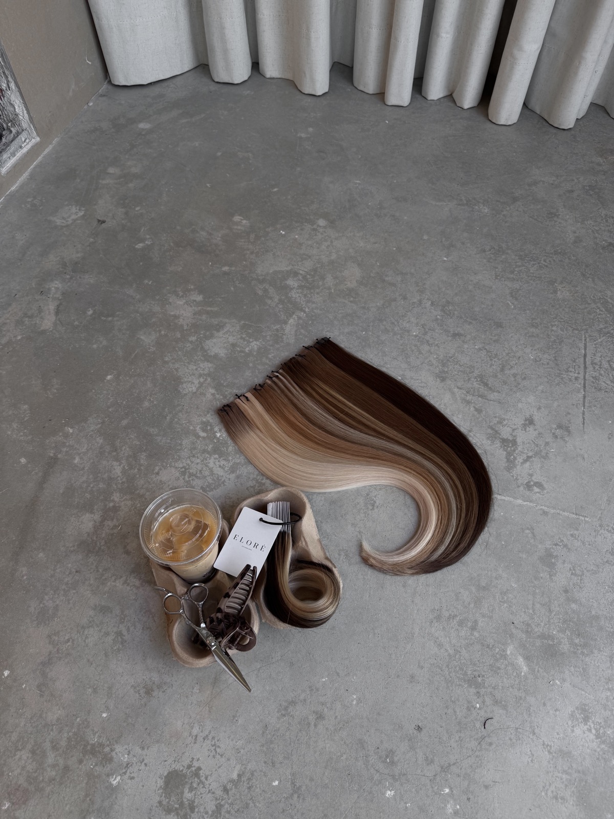 Extensiones de cabello y tijeras sobre el suelo de hormigón, taller Garage
